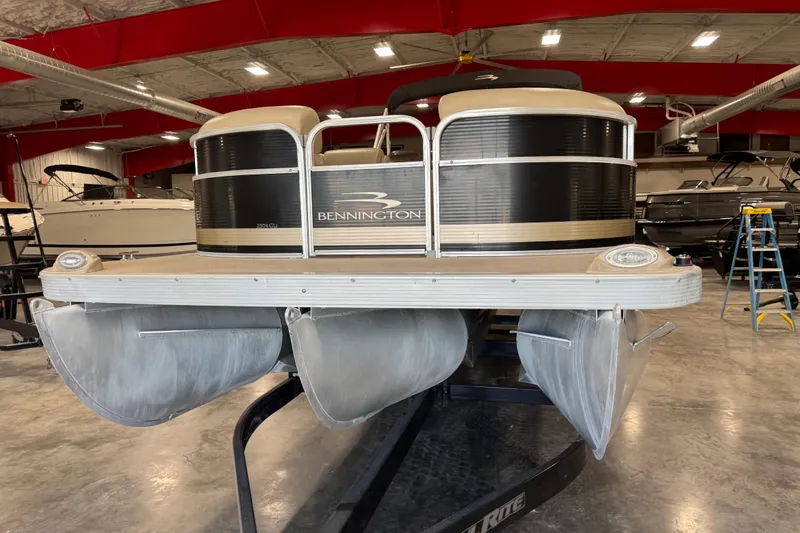 Slide: The Image of 2010 Bennington 2574GLi pontoon boat in a showroom with red ceiling beams. - 5