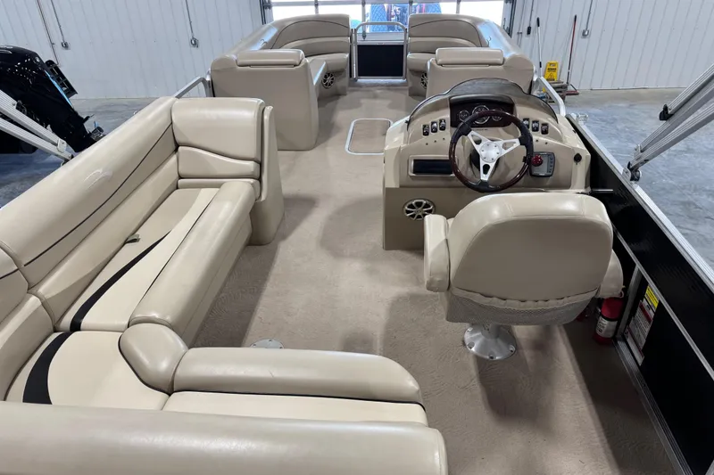 Slide: The Image of 2010 Bennington 2574GLi pontoon boat interior with beige seating and steering console. - 8