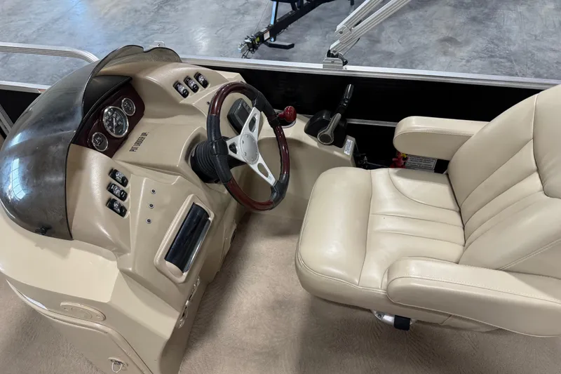 Slide: The Image of 2010 Bennington 2574GLi boat interior with steering wheel and beige captain's chair. - 9