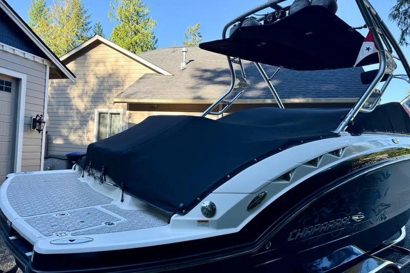 Slide: The Image of 2009 Chaparral Sunesta 224 Xtreme boat with cover, parked near a house. - 11