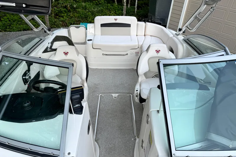 Slide: The Image of 2009 Chaparral Sunesta 224 Xtreme boat interior with white seating and steering wheel. - 20