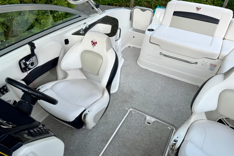 Slide: The Image of 2009 Chaparral Sunesta 224 Xtreme boat interior with white seating and steering wheel. - 21