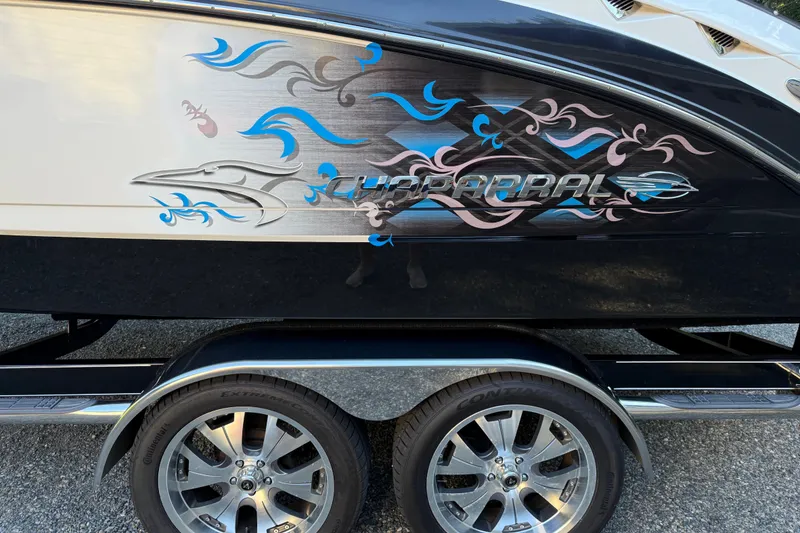 Slide: The Image of 2009 Chaparral Sunesta 224 Xtreme boat with colorful graphics and trailer wheels. - 4