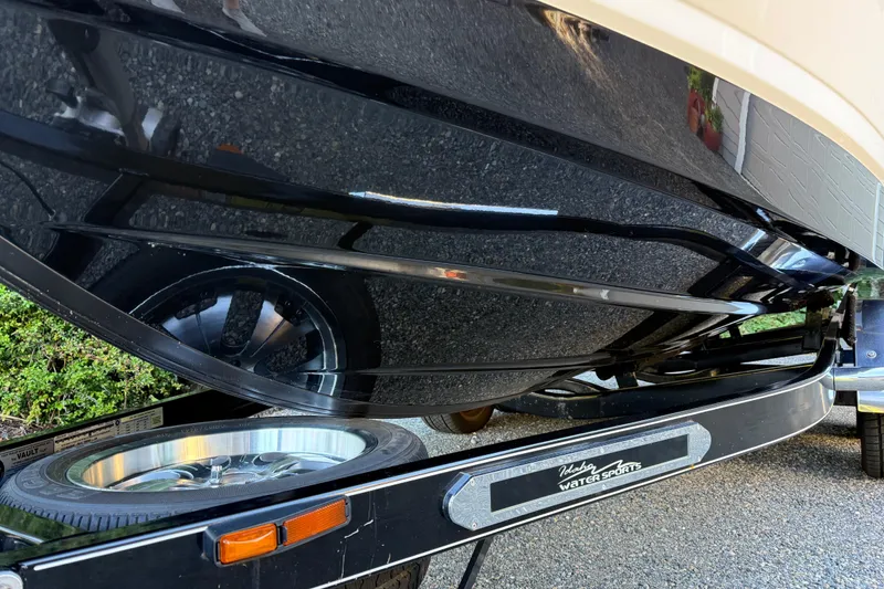 Slide: The Image of 2009 Chaparral Sunesta 224 Xtreme boat on trailer, showcasing sleek black hull design. - 5