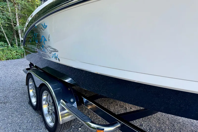 Slide: The Image of 2009 Chaparral Sunesta 224 Xtreme boat on trailer, side view with decorative graphics. - 8