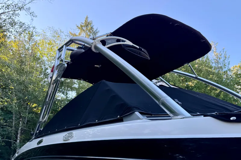 Slide: The Image of 2009 Chaparral Sunesta 224 Xtreme boat with canopy, surrounded by trees. - 9