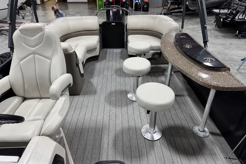 Slide: The Image of 2021 Manitou 23 Oasis boat interior with plush seating and bar area. - 10