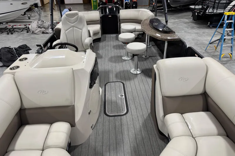 Slide: The Image of 2021 Manitou 23 Oasis pontoon boat interior with plush seating and modern helm. - 11