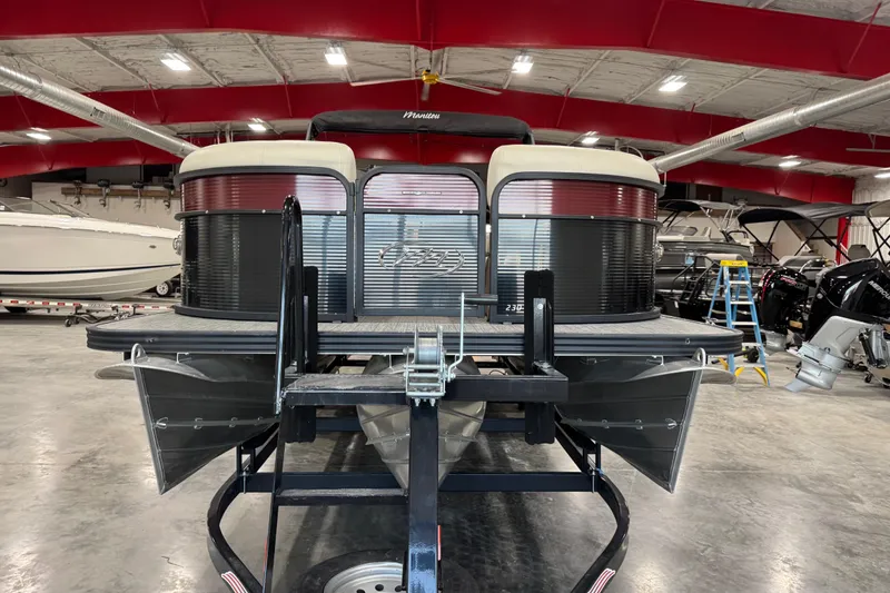 Slide: The Image of 2021 Manitou 23 Oasis pontoon boat in a showroom with red ceiling. - 6