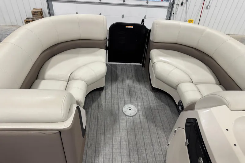 Slide: The Image of 2021 Manitou 23 Oasis boat interior with beige seating and gray flooring. - 9