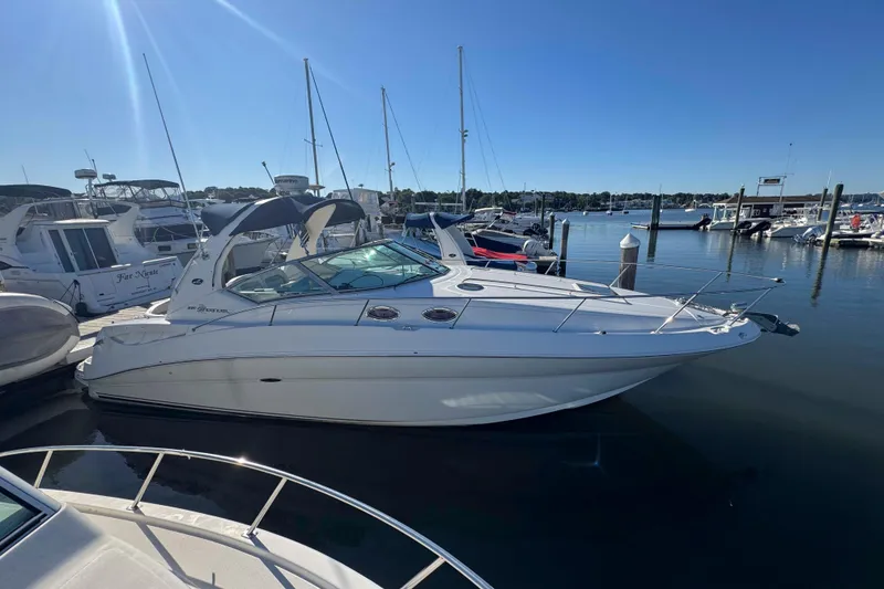 The Image of 2002 Sea Ray 320 Sundancer yacht docked in a marina under clear blue skies. - 0
