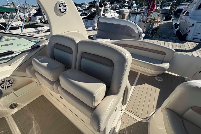 Slide: The Image of 2002 Sea Ray 320 Sundancer interior with beige seating, docked at marina. - 10