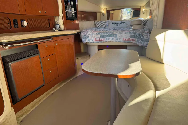 Slide: The Image of Interior of 2002 Sea Ray 320 Sundancer with cozy seating and compact kitchenette. - 16