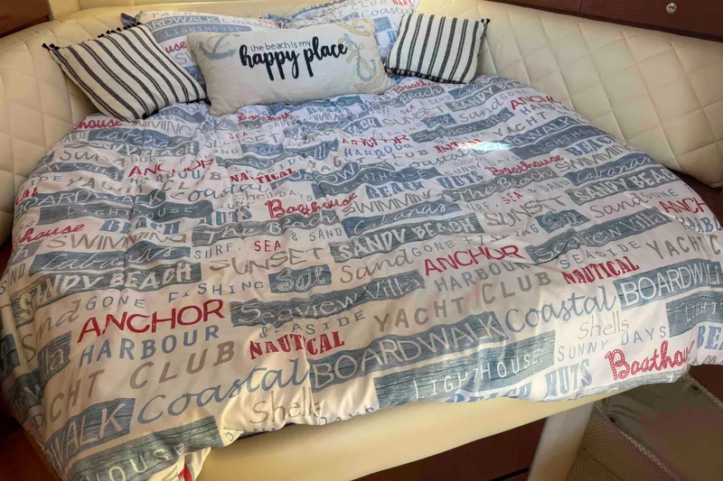 Slide: The Image of Cozy bed with nautical-themed bedding on a 2002 Sea Ray 320 Sundancer yacht. - 19