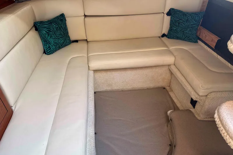 Slide: The Image of Interior seating area of a 2002 Sea Ray 320 Sundancer with beige cushions and decorative pillows. - 20