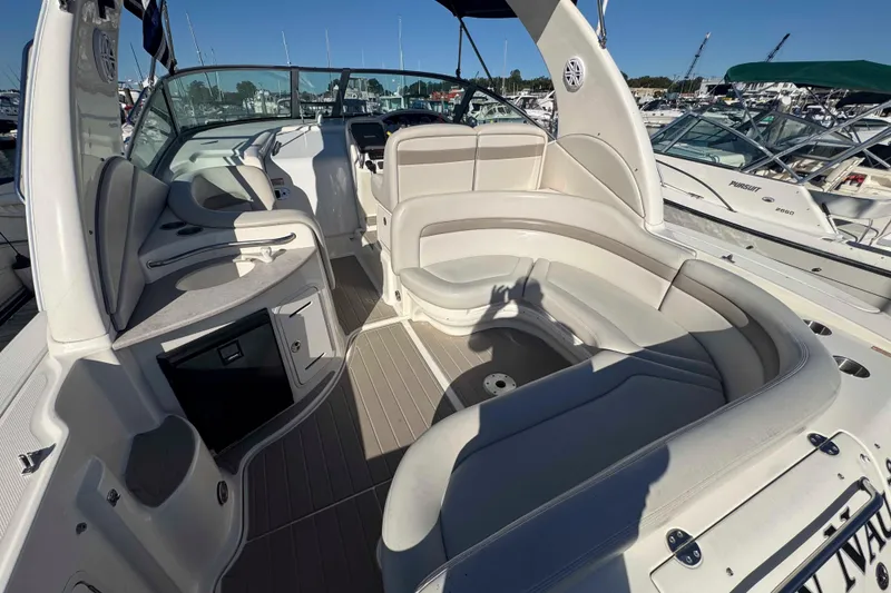 Slide: The Image of 2002 Sea Ray 320 Sundancer boat interior with seating and helm, docked at marina. - 6