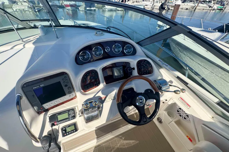 Slide: The Image of Cockpit view of 2002 Sea Ray 320 Sundancer, featuring steering wheel and navigation instruments. - 7