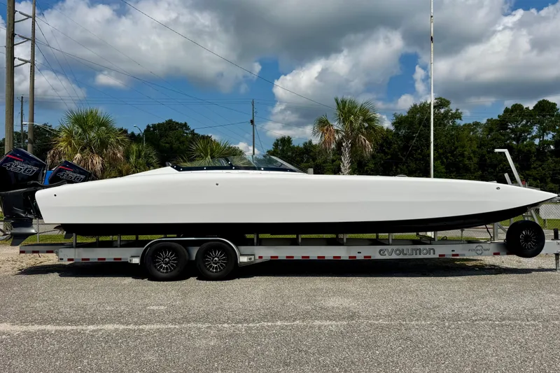 Slide: The Image of 2024 Fountain 34 Thundercat boat on trailer, parked outdoors under cloudy sky. - 2