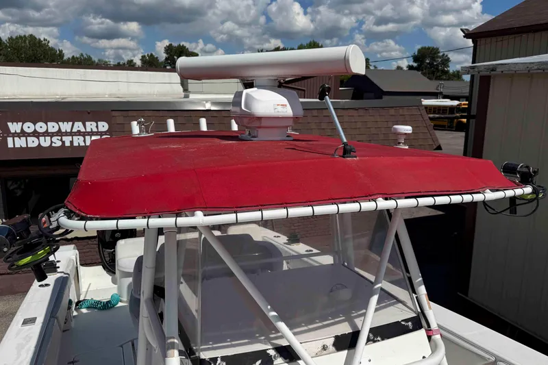 Slide: The Image of 2008 Fountain 38 Tournament Edition boat with red canopy and radar, parked at Woodward Industries. - 12