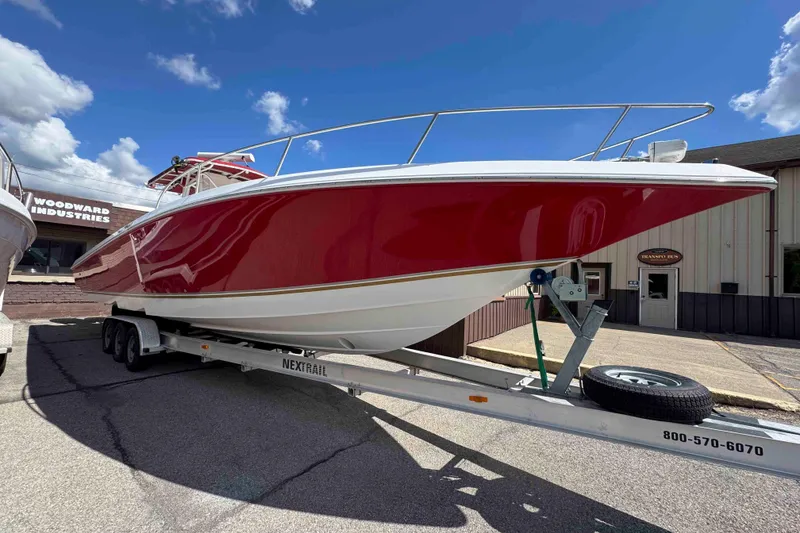 Slide: The Image of 2008 Fountain 38 Tournament Edition boat on trailer, red hull, parked outdoors. - 2