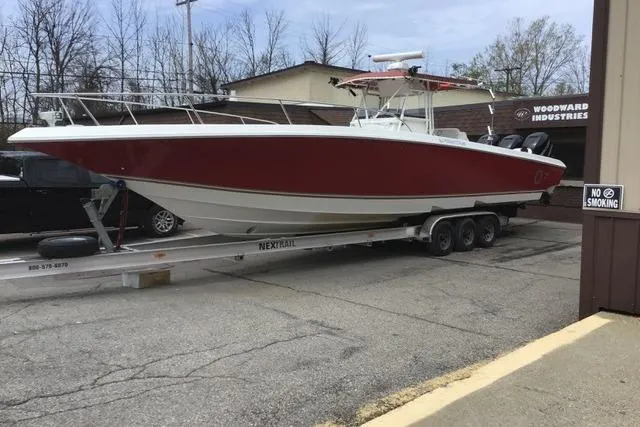Slide: The Image of 2008 Fountain 38 Tournament Edition boat on trailer, red and white design, parked outside. - 3