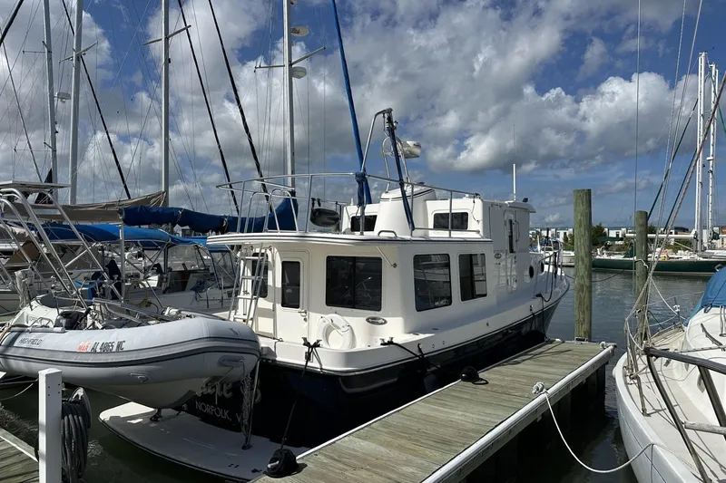Slide: The Image of 2005 American Tug 34 Pilothouse docked at a marina under a cloudy sky. - 122