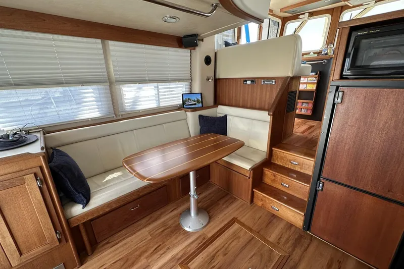 Slide: The Image of Interior of 2005 American Tug 34 Pilothouse with wood finishes and cozy seating area. - 15