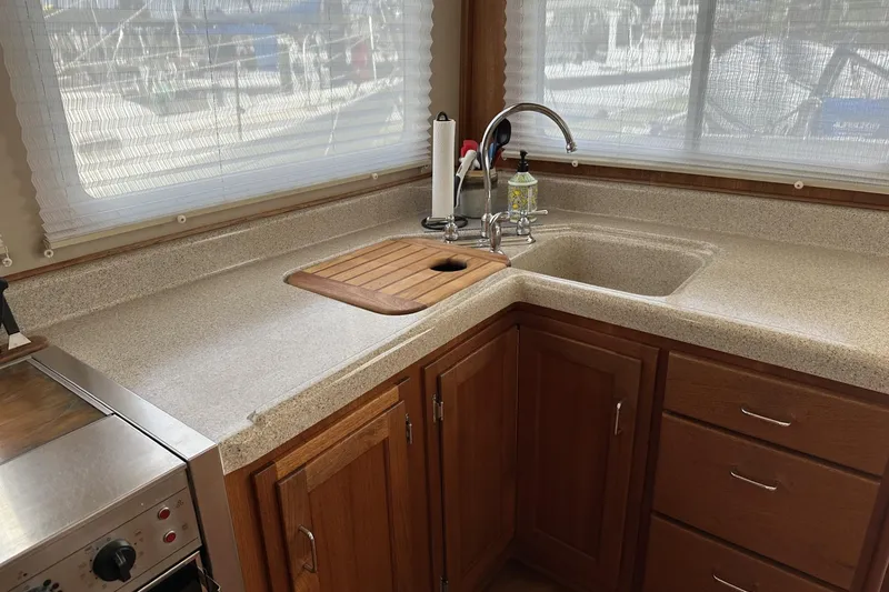 Slide: The Image of 2005 American Tug 34 Pilothouse kitchen with sink, wooden cabinets, and countertop. - 19