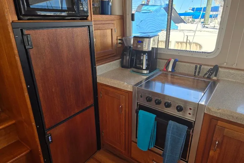 Slide: The Image of 2005 American Tug 34 Pilothouse kitchen with stove, fridge, and coffee maker. - 20