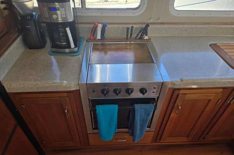 Slide: The Image of Galley kitchen in 2005 American Tug 34 Pilothouse with stove, coffee maker, and knives. - 22