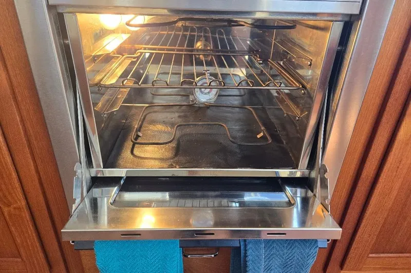 Slide: The Image of Open oven in 2005 American Tug 34 Pilothouse, with interior light on and towels hanging. - 25