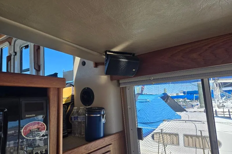 Slide: The Image of Interior of 2005 American Tug 34 Pilothouse with speaker and window view of marina. - 27