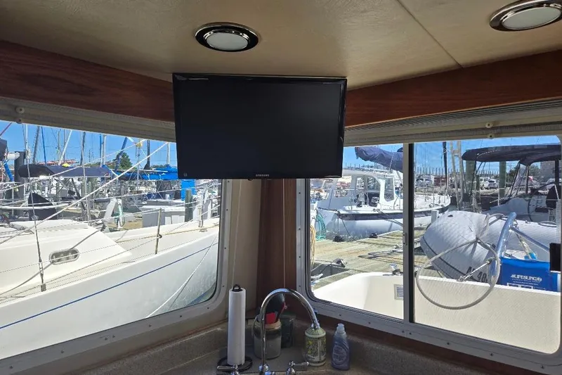 Slide: The Image of Interior view of 2005 American Tug 34 Pilothouse with marina backdrop. - 28