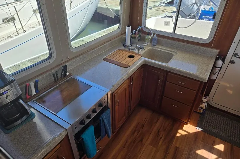 Slide: The Image of 2005 American Tug 34 Pilothouse kitchen with stove, sink, and wooden cabinetry. - 3