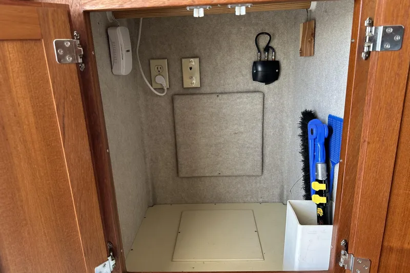 Slide: The Image of Storage cabinet in 2005 American Tug 34 Pilothouse with cleaning tools and electrical outlets. - 31