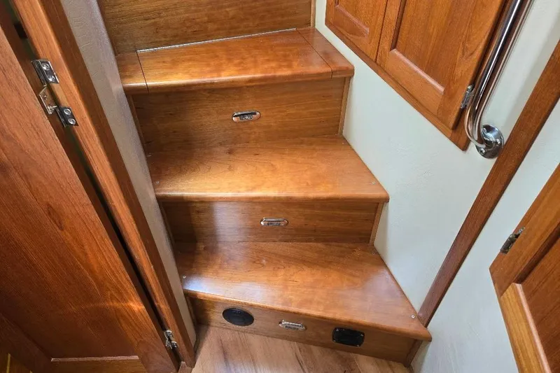 Slide: The Image of Wooden stairs inside a 2005 American Tug 34 Pilothouse boat, featuring polished handrails. - 32