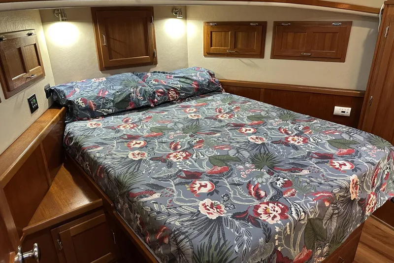 Slide: The Image of Cozy bedroom in 2005 American Tug 34 Pilothouse with floral bedding and wooden cabinetry. - 34