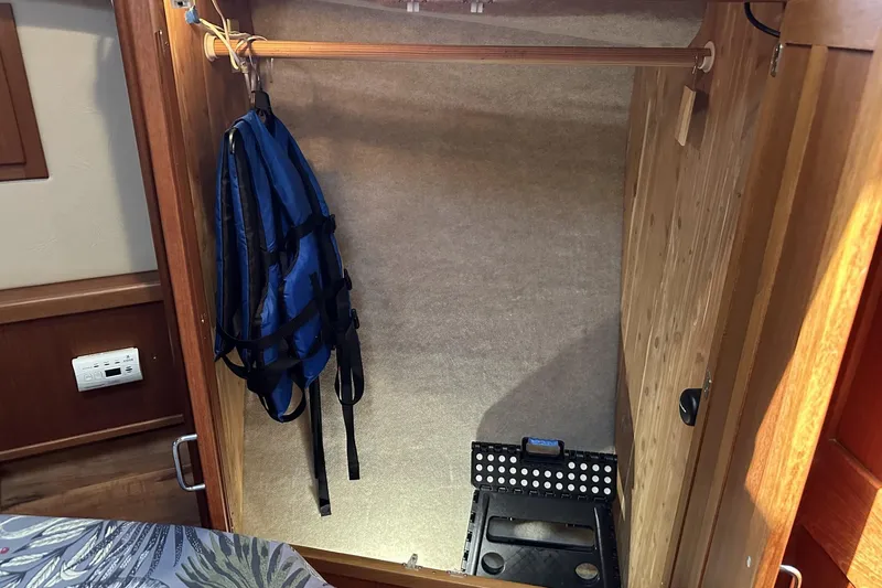Slide: The Image of 2005 American Tug 34 Pilothouse closet interior with blue backpack and step stool. - 39
