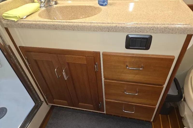 Slide: The Image of 2005 American Tug 34 Pilothouse bathroom vanity with wooden cabinets and drawers. - 41