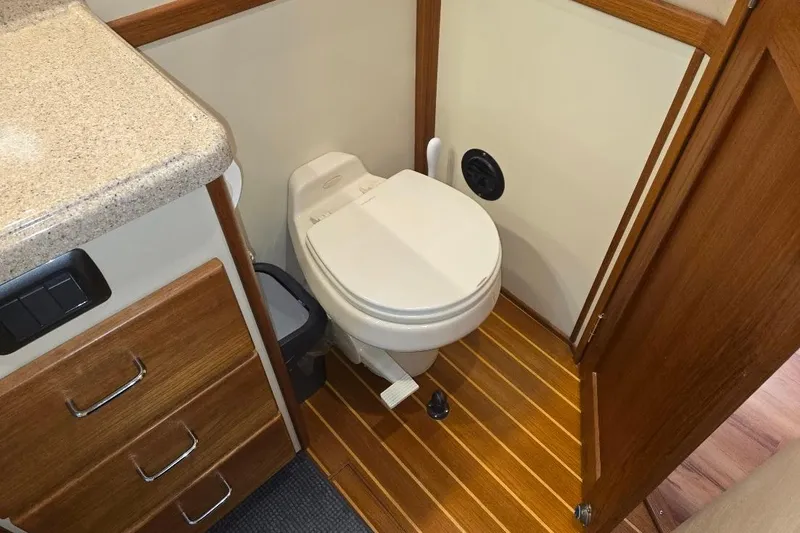 Slide: The Image of 2005 American Tug 34 Pilothouse bathroom with wooden flooring and compact toilet. - 43