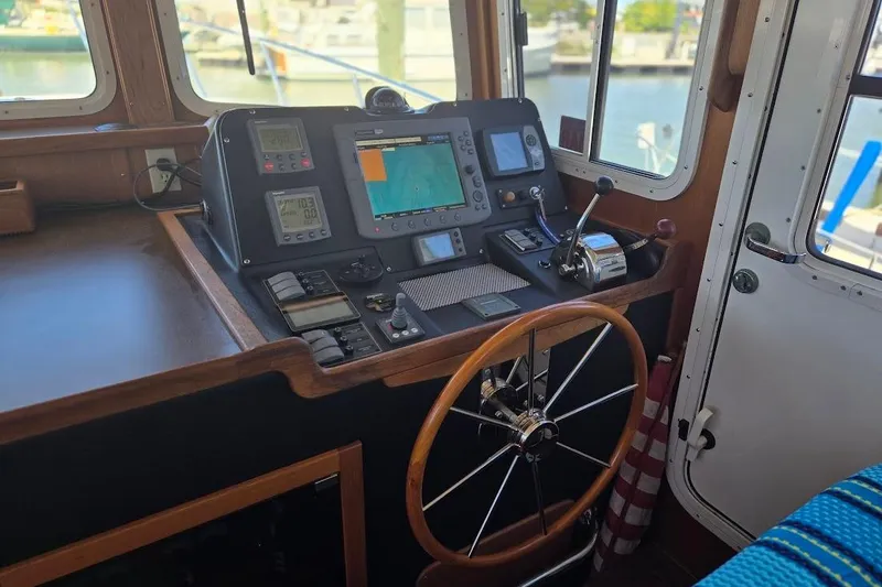 Slide: The Image of Pilothouse interior of 2005 American Tug 34, featuring navigation equipment and steering wheel. - 45