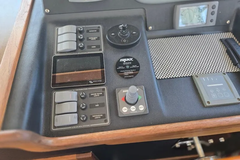 Slide: The Image of Control panel of a 2005 American Tug 34 Pilothouse boat, featuring various switches and gauges. - 50