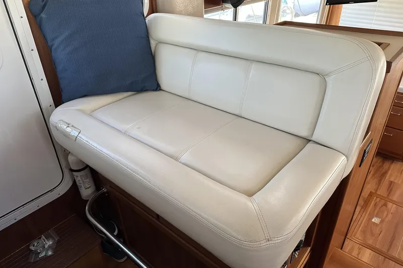 Slide: The Image of 2005 American Tug 34 Pilothouse interior with white leather seating and blue cushion. - 55