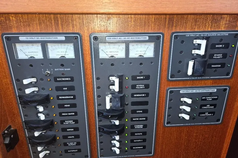 Slide: The Image of Electrical panel of a 2005 American Tug 34 Pilothouse, featuring various switches and meters. - 58