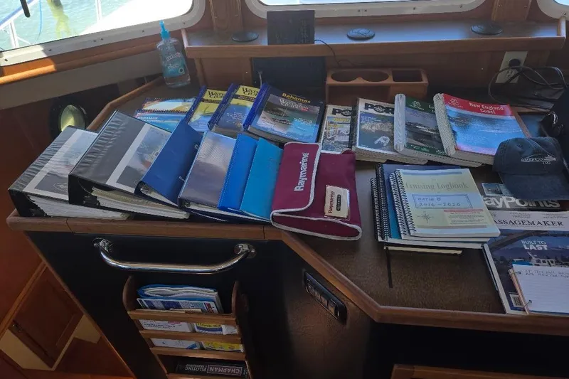 Slide: The Image of Pilothouse interior of 2005 American Tug 34 with navigation charts and logbooks. - 63