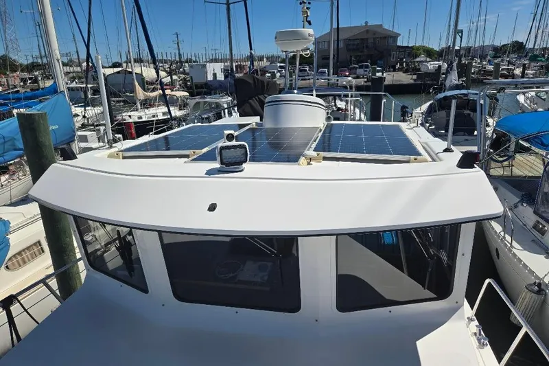 Slide: The Image of 2005 American Tug 34 Pilothouse with solar panels, docked in a marina. - 68