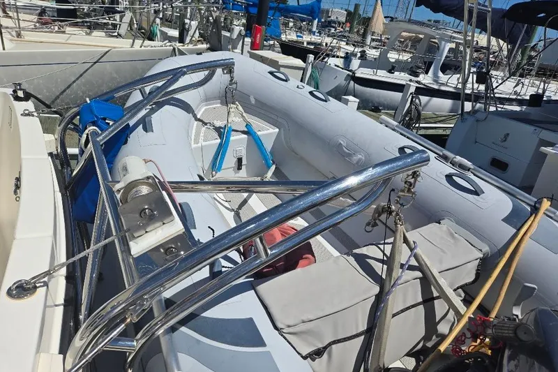 Slide: The Image of 2005 American Tug 34 Pilothouse boat docked, featuring a spacious deck and safety railings. - 77