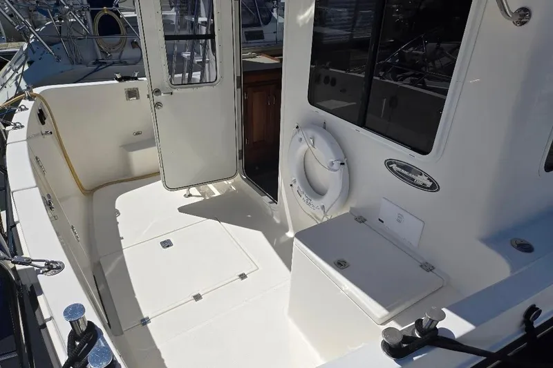 Slide: The Image of 2005 American Tug 34 Pilothouse boat deck with open door and life preserver. - 83