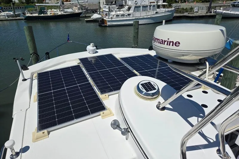 Slide: The Image of 2005 American Tug 34 Pilothouse with solar panels on deck, docked at marina. - 92