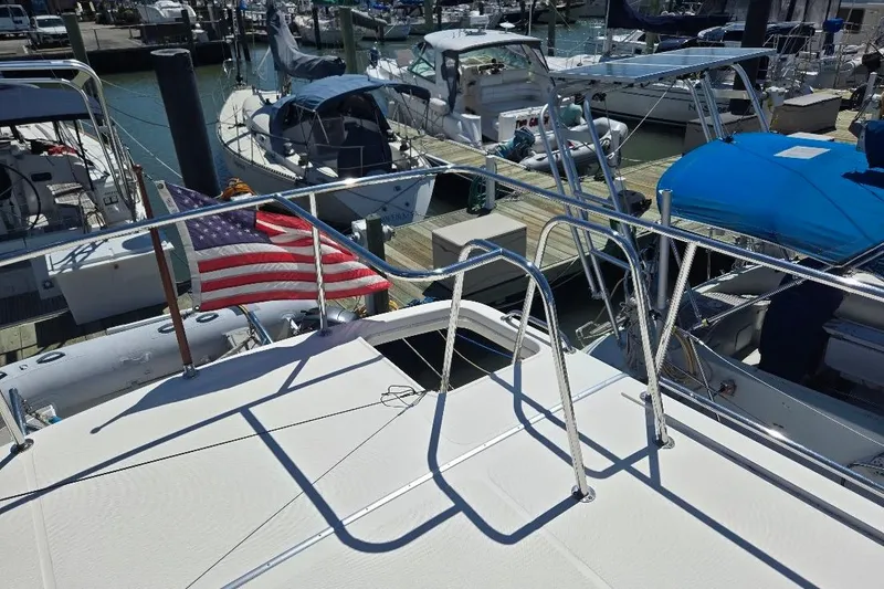 Slide: The Image of 2005 American Tug 34 Pilothouse at marina with American flag, surrounded by boats. - 95